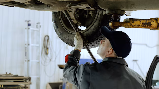 skilled-automotive-technician-checking-vehicle-undercarriage-with-pry-bar